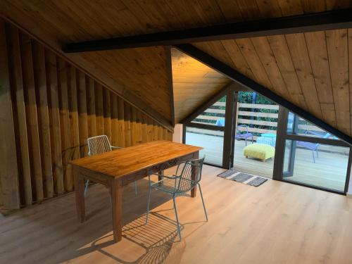 una mesa de madera y 2 sillas en una habitación en Il était une fois sous l’arbre, en Saint-André