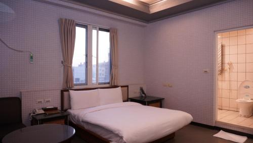 a hotel room with a bed and a window at Wind Coast Motel in Hsinchu City