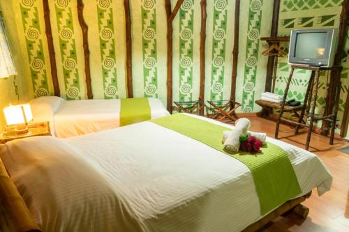 a bedroom with two beds with a teddy bear on it at San Agustin Internacional Hotel in San Agustín