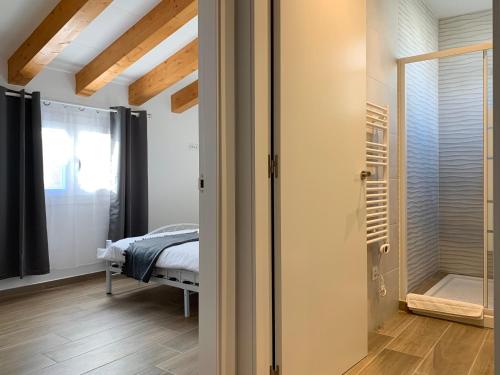 - une chambre avec un lit et une porte en verre dans l'établissement Vila Badalona, à Badalona