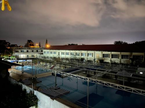 a building with a pool in front of it at night at Khách sạn Nguyên Long in Bao Loc