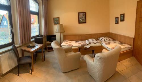 a room with a bed and a table and chairs at Villa Borchert in Wernigerode