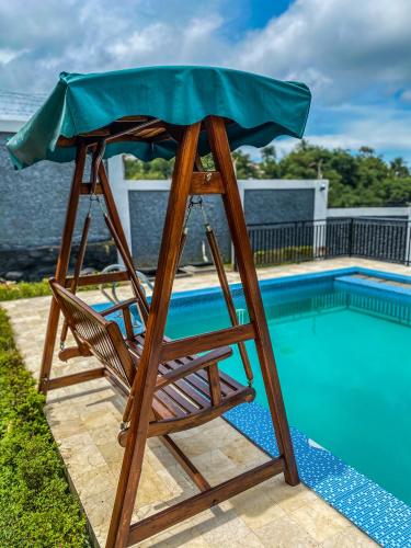 a wooden chair sitting next to a swimming pool at AL Marina Resort in Puncak