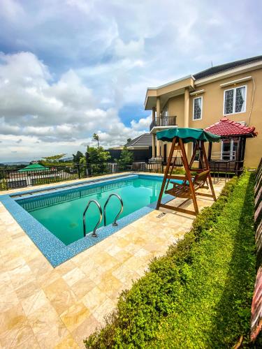 a swimming pool with a table next to a house at AL Marina Resort in Puncak