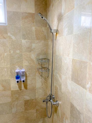 a shower with a shower head in a bathroom at AL Marina Resort in Puncak