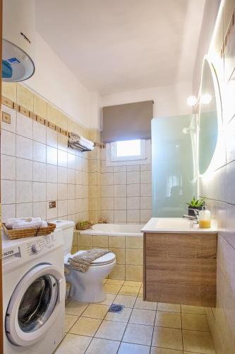 a bathroom with a washing machine and a toilet at Joy cozy apartment in Iraklitsa