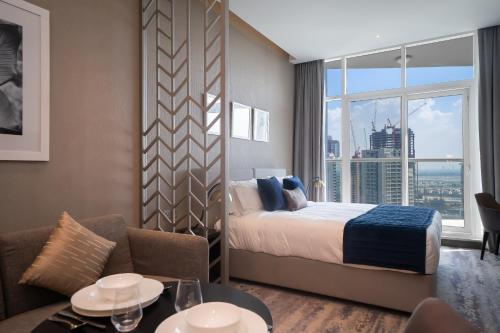 a hotel room with a bed and a large window at Luton Vacation Homes - Damac Maison Prive Studio, Canal View, Dubai - 16AB03 in Dubai