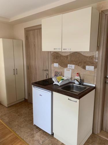 a kitchen with white cabinets and a sink at Apartmani Ristanović in Zlatibor
