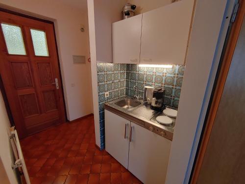 małą kuchnię ze zlewem i drzwiami w obiekcie Appartement w mieście Dötzingen