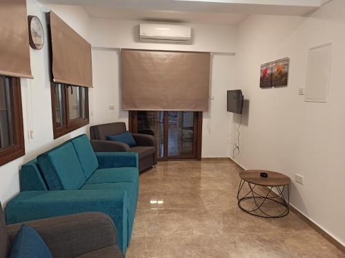 a living room with a blue couch and a tv at River Apartments in Galata