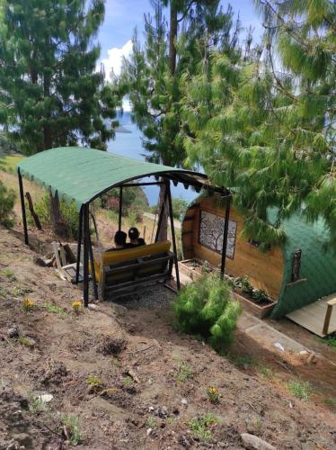 two people sitting in a gazebo near a lake at Costa Azul Ecolodge in Aquitania