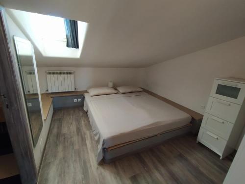 Dormitorio pequeño con cama y espejo en CLALU - casa vacanze Senigallia, en Senigallia