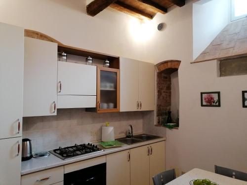 a kitchen with white cabinets and a stove top oven at Residenza Le Peonie in Todi