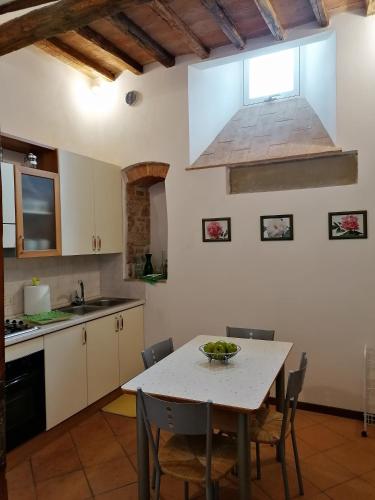 a kitchen with a table with a bowl of fruit on it at Residenza Le Peonie in Todi