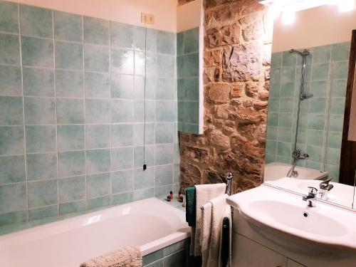 a bathroom with a bath tub and a sink at Residenza Le Peonie in Todi