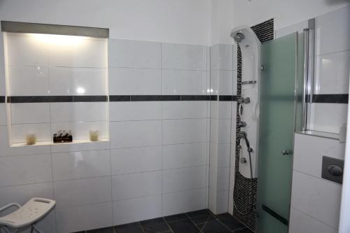 y baño con ducha y azulejos blancos y negros. en Schönberg - Schuster Raths Kate, en Schönberg in Holstein