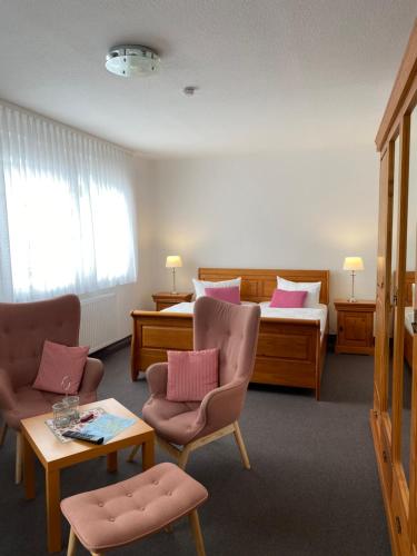 una camera d'albergo con un letto, due sedie e un tavolo di Pension Marion a Binz