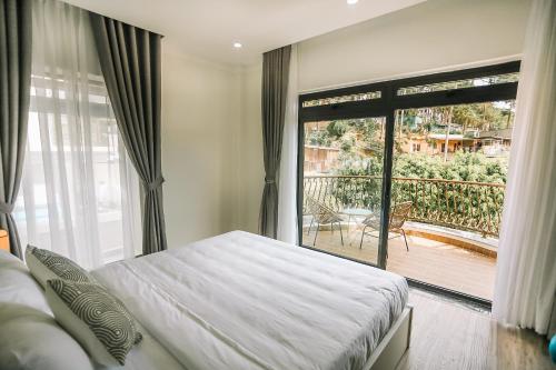 Un dormitorio con una cama y una ventana grande. en Memory Inn - Green Villa, en Da Lat