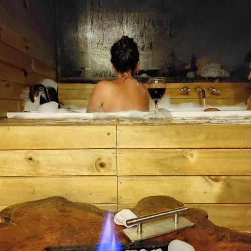 a man in a bath tub with a glass of wine at Costa Azul Ecolodge in Aquitania