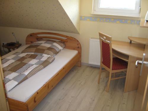 een slaapkamer met een bed, een bureau en een tafel bij Ferienwohnung Sauerland Panorama in Korbach