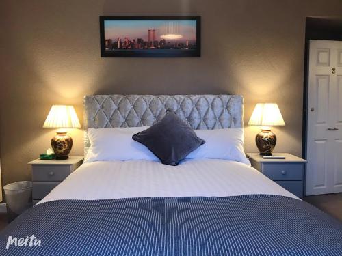 a bedroom with a large bed with two lamps at Mulgrave Lodge in Dun Laoghaire