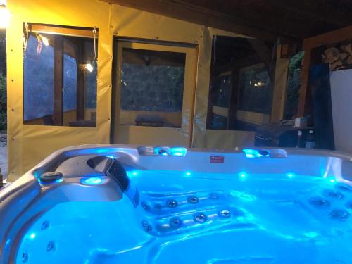 Noszvaj Elite Apartman في نوسفاج: حوض استحمام أزرق مع أضواء في الغرفة