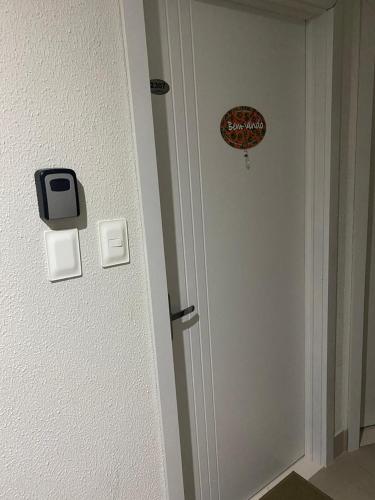 a door in a room with a sign on the wall at "Conforto e Bem Estar" Próximo da praia in Balneário Camboriú