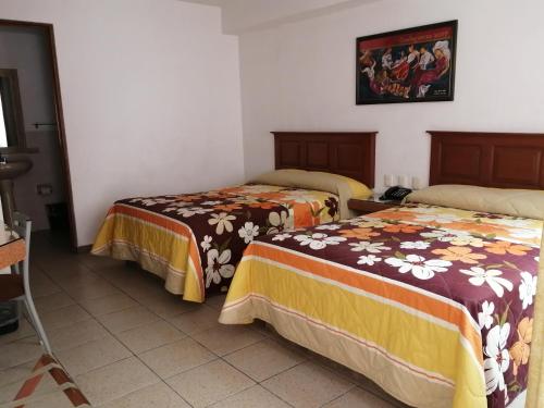 a room with two beds in a room at Hotel Camba in Oaxaca City