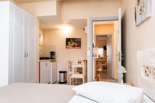 a bedroom with a white bed and a kitchen at Villa Aegeon in Megalokhori
