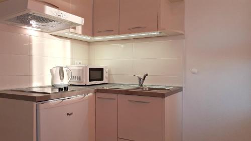 a small kitchen with a microwave and a sink at Stone House Bonaca with Sea View in Baška Voda