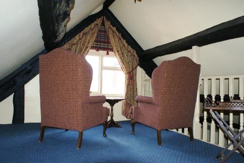 two chairs sitting in a room with a window at The Old Black Lion in Hay-on-Wye