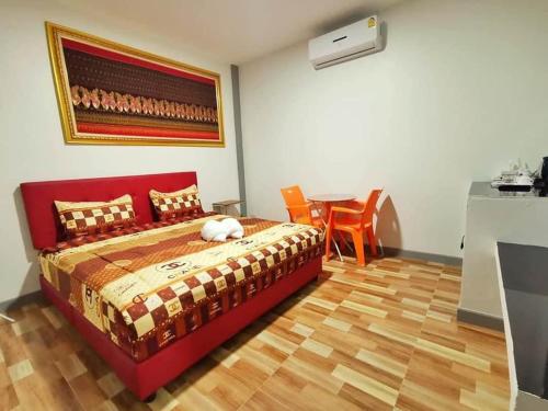 ein Schlafzimmer mit einem Bett und einem Tisch in einem Zimmer in der Unterkunft PP Nongkhai Resort in Nong Khai