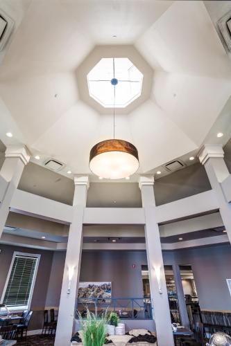 a ceiling in a lobby with a light fixture at Royal Hotel Calgary, Trademark Collection by Wyndham in Calgary