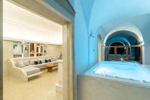 eine große Badewanne in einem Zimmer mit einem Wohnzimmer in der Unterkunft Villa Leon in Vourvoúlos