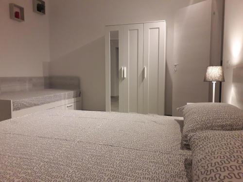 a white bedroom with a bed and a mirror at Fontanarossa Airport Sleep and Travel in Catania