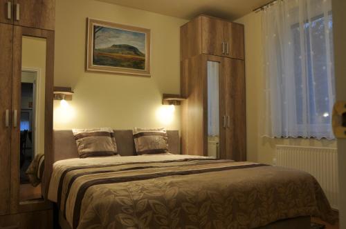 a bedroom with a large bed with two pillows at Herbert Apartman in Bük