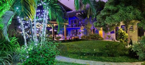 a house with lights in the yard at night at Residencial Vilamar in Ilhabela