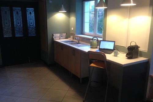- une cuisine avec un bureau et un ordinateur portable dans l'établissement Bel appartement en rez-de-jardin, à Cherbourg en Cotentin