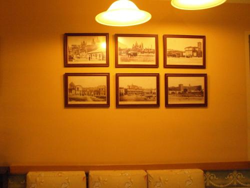 a group of pictures on a wall with a couch at Hostal Orejas in León