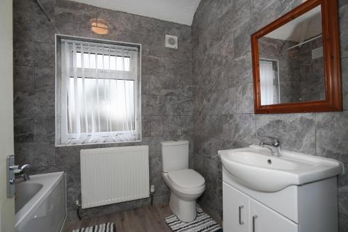 a bathroom with a sink toilet and a mirror at BIRMINGHAM HAGLEY WEST HOUSE, 5 bedrooms with 7 BEDS, 3x doubles beds, 4x singles beds,2 toilets,2 bathrooms,2 toilets, sleeps 7-10 people great motorway links M5 M6 M42 A38 A34 in Birmingham