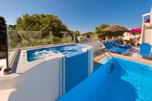 a pool with chairs and a swimming pool at Villa Aegeon in Megalokhori
