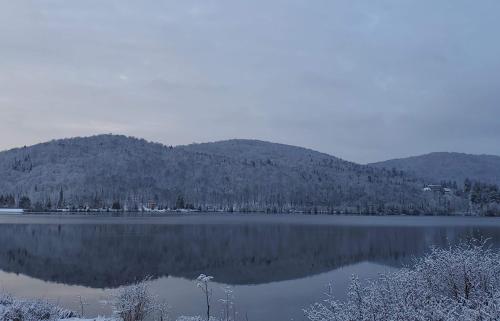 a view of a lake with mountains in the background at Auberge Hotel Spa Watel in Sainte-Agathe-des-Monts
