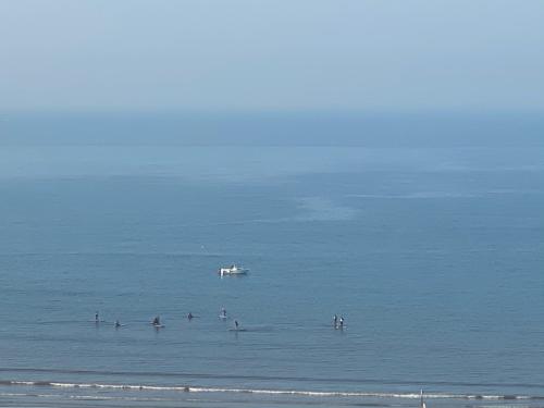 a group of people in the ocean with a boat at Acre sea view 11th floor apartment in ‘Akko