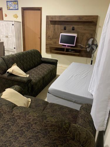 um quarto com uma cama, um sofá e uma televisão em Casa Próximo ao Beto Carrero e Praia em Penha