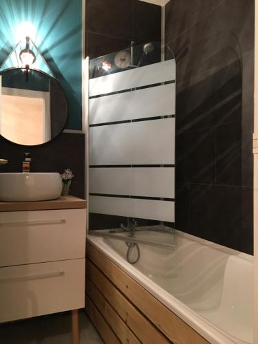 une salle de bain avec une baignoire et un lavabo dans l'établissement La Timonerie - La Caraque 35, vue mer et dunes classé 2 étoiles, à Fort-Mahon-Plage