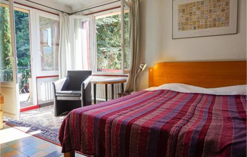 Schlafzimmer mit einem Bett, einem Stuhl und Fenstern in der Unterkunft 3 Bedroom Pet Friendly Home In Lamalou-les-bains 