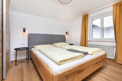 a bed in a room with a large window at Chalet Sonnrain in Sankt Martin am Tennengebirge