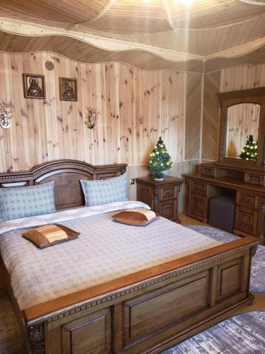 a bedroom with a large bed and a wooden wall at Sadyba Medova nasoloda in Guta