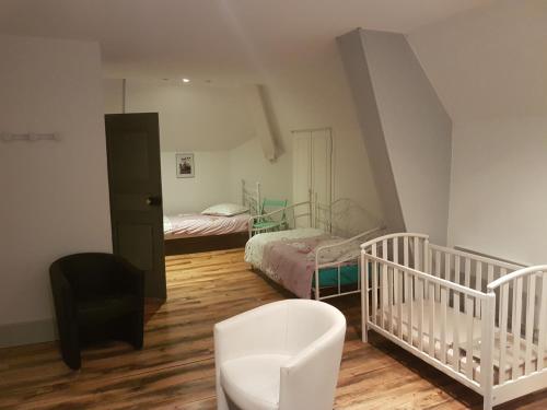 - une chambre avec 2 lits et un lit bébé dans l'établissement Le Betrot, à Estissac