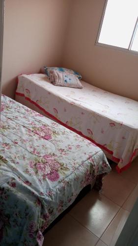 two beds sitting next to each other in a room at Apartamento no val in Valparaíso de Goiás